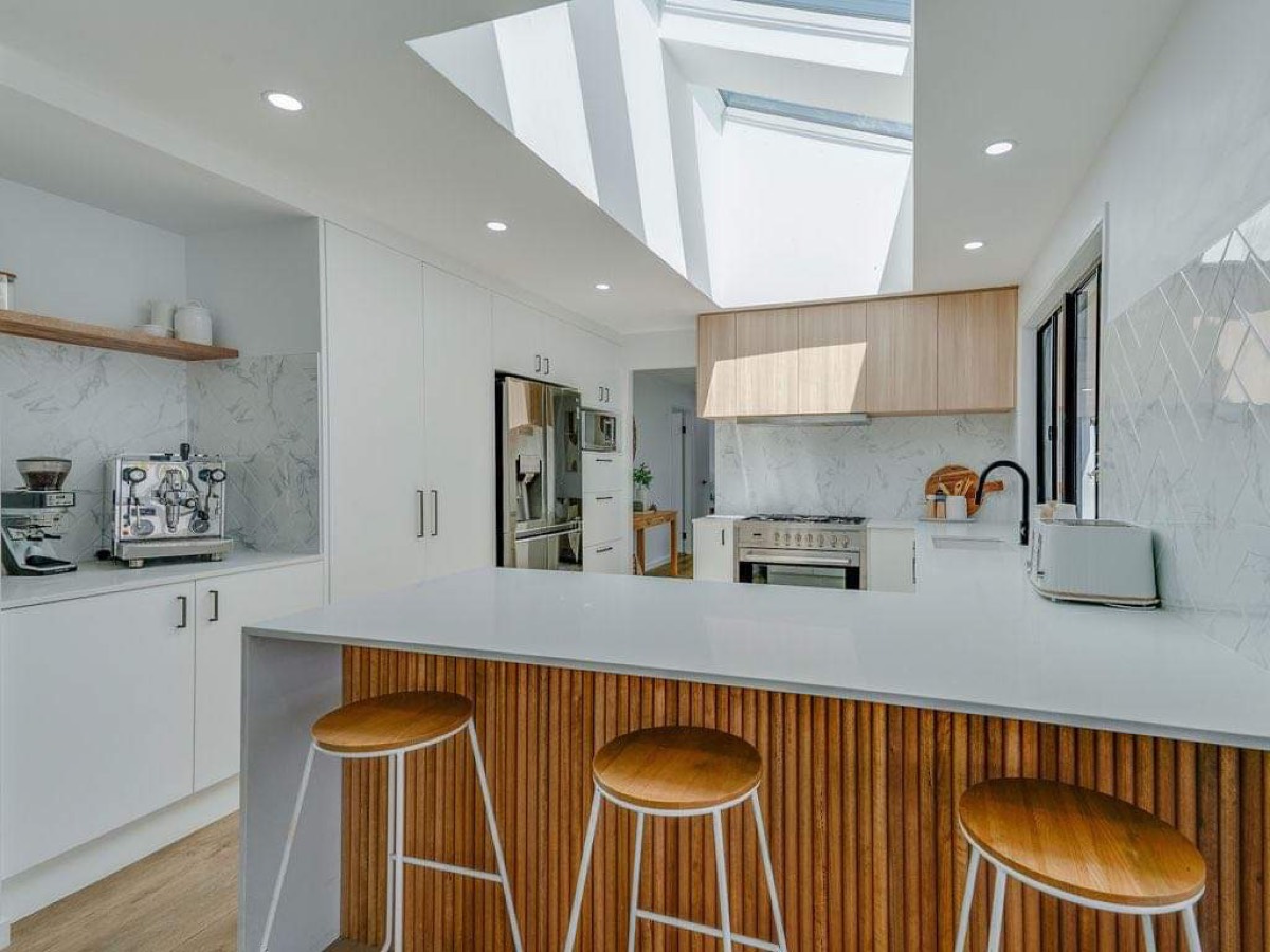 Renovated kitchen with timber battens, stone benchtops and skylights